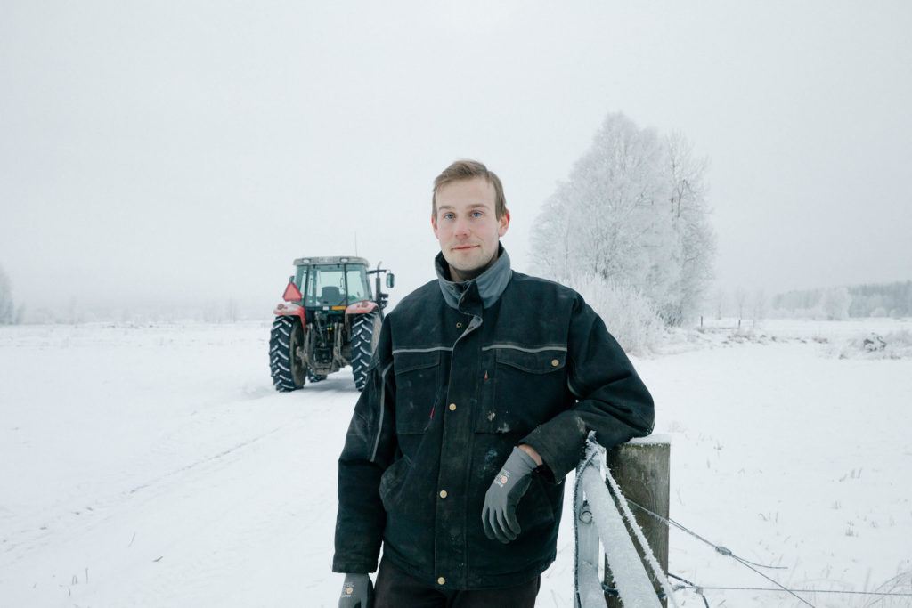 Man in front of white winter landscape and tractor